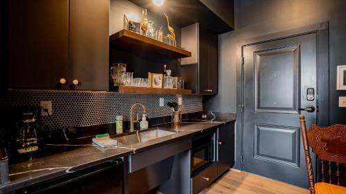 a kitchen with stainless steel sinks and a blue door at Pickle Factory - Wenzel Luxe in Covington