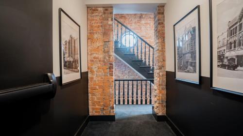 a hallway with pictures on the walls and a staircase at Pickle Factory - Wenzel Luxe in Covington