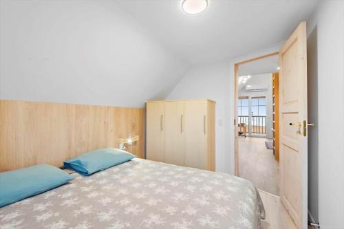 a bedroom with a large bed with blue pillows at 0236-Romo-Havnebyvej-61-G in Kongsmark