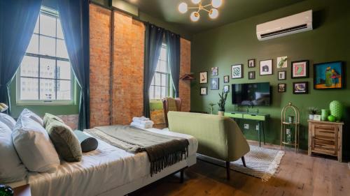 a green bedroom with a bed and a television at Pickle Factory - In A Pickle Retro Loft 2 bedroom in Covington