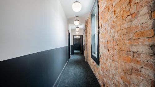 a hallway with a red brick wall and lights at Pickle Factory - In A Pickle Retro Loft 2 bedroom in Covington