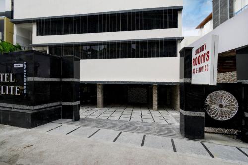 a building with a parking lot in front of it at Hotel O P R S Elite in Surūrnagar