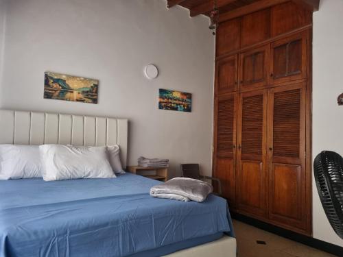 a bedroom with a blue bed and a wooden closet at Amplia y Cómoda casa en la 70 in Medellín