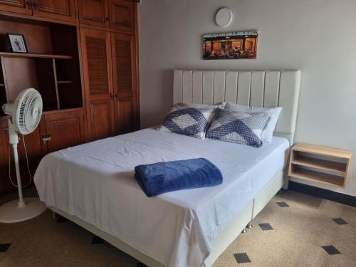 a bedroom with a bed with a blue pillow on it at Amplia y Cómoda casa en la 70 in Medellín