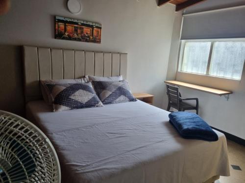 a bedroom with a bed with a blue pillow on it at Amplia y Cómoda casa en la 70 in Medellín