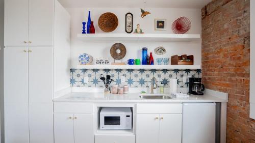 a kitchen with white cabinets and a microwave at Pickle Factory - Odd Fellows Hall in Covington