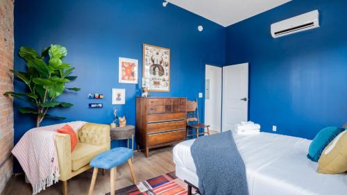 a blue bedroom with a bed and a chair at Pickle Factory - Odd Fellows Hall in Covington