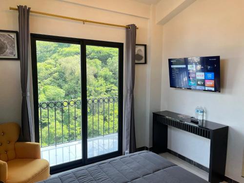 a bedroom with a large window with a view at HOTEL BOUTIQUE ÁRBOL De LA VIDA in Taxco de Alarcón