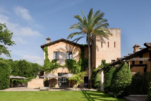an old building with a palm tree in front of it at QC Grand Hotel Roma in Fiumicino