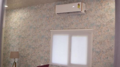 a room with a window and a air conditioner on the wall at The Green Arc in Gurgaon