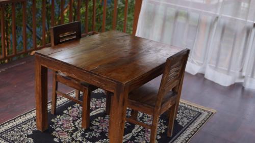 a wooden table and chair sitting on a rug at The Green Arc in Gurgaon