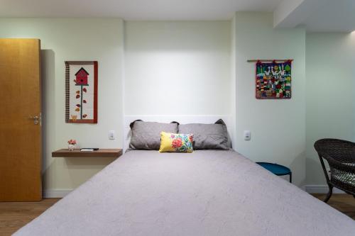 Un dormitorio con una cama grande con una almohada. en Apartamento em Itaipava com Piscina e Academia, en Itaipava