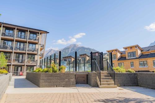 a group of buildings with mountains in the background at Timberstone Condo by Canadian Rockies Vacation Rentals in Canmore
