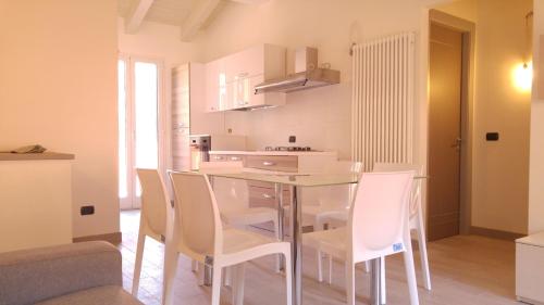a kitchen and dining room with a glass table and chairs at Il Cuore del Borgo - Holiday Home in Borgomaro