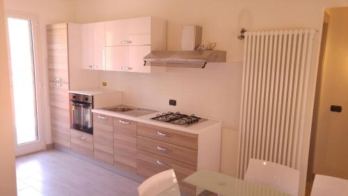 a kitchen with white cabinets and a stove top oven at Il Cuore del Borgo - Holiday Home in Borgomaro