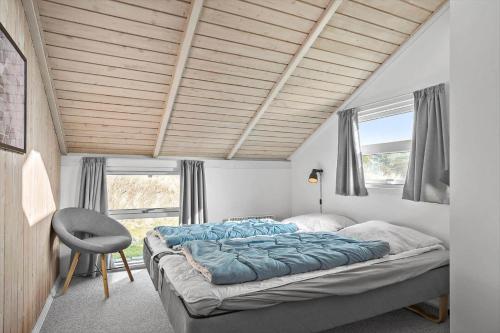 Un dormitorio con una cama grande y una silla. en 0017-Romo-Magevej-7, en Lakolk