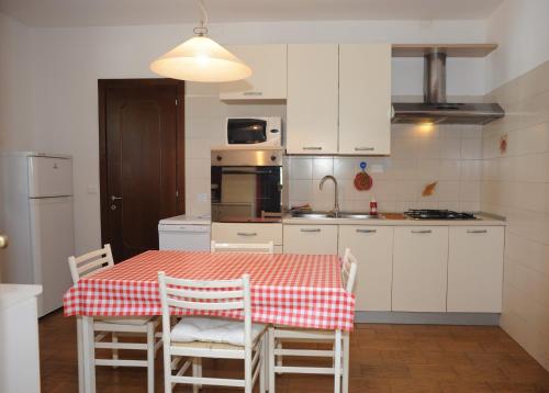 a kitchen with a red and white table and chairs at Casa Vacanze Riviera del Brenta in Dolo