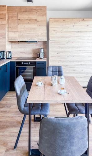 a kitchen with a wooden table and chairs at Apartmán s krásným výhledem na jezera a Pálavu in Pasohlávky