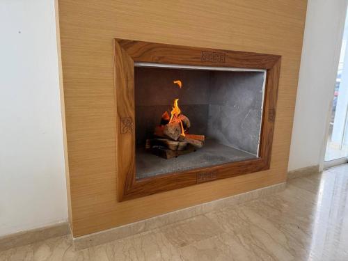 a fireplace with a fire in it in a room at La Villa des Rochers in Temara