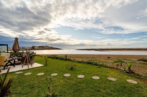 a patio with a view of a body of water at La Villa des Rochers in Temara