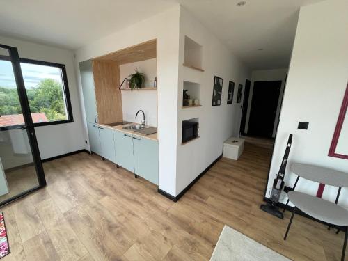 a large kitchen with a sink and a window at Maison 2 chambres avec terrasse in Doullens