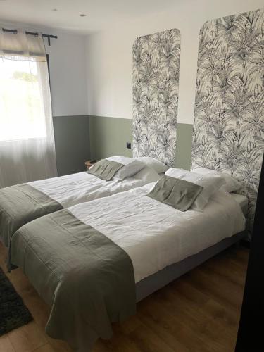 a bedroom with a large bed with white sheets and a window at Maison 2 chambres avec terrasse in Doullens