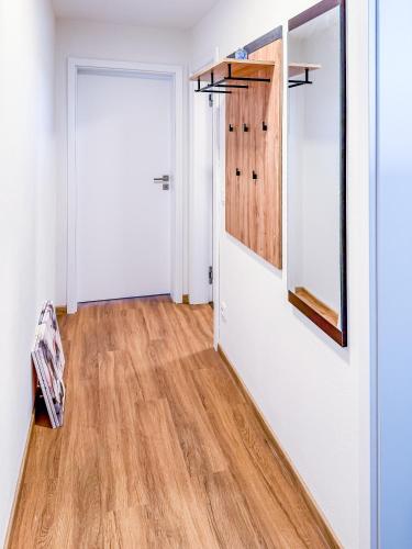 a hallway with a white door and wooden floors at Apartmán s krásným výhledem na jezera a Pálavu in Pasohlávky