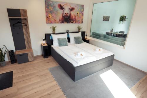 a bedroom with a bed with a large painting on the wall at Wohlfühlapartment - Künzell in Künzell