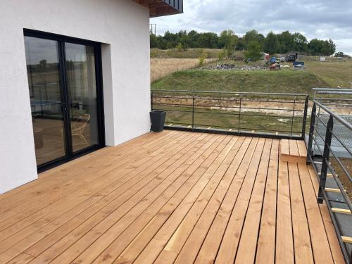 a wooden deck with a view of a field at Maison 2 chambres avec terrasse in Doullens