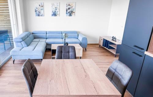 a living room with a table and a blue couch at Apartmán s krásným výhledem na jezera a Pálavu in Pasohlávky