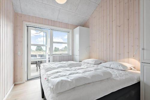 a large white bed in a room with a window at 0257-Romo-Chresten-Krommes-Vej-9 in Tagholm