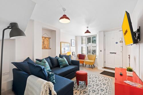 a living room with a blue couch and a table at Hosted by StaySejour - 7Beds - Town House - Free Parking - outside space in Brighton & Hove