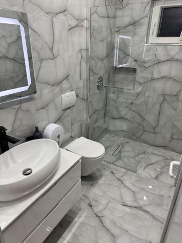 a bathroom with a toilet and a sink and a shower at London Restaurant Hotel in Kukës