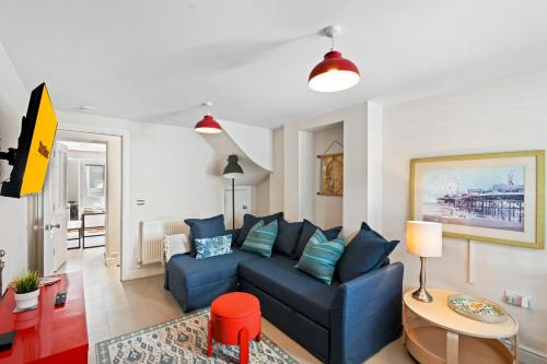 a living room with a blue couch and a table at Hosted by StaySejour - 7Beds - Town House - Free Parking - outside space in Brighton & Hove