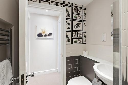 a bathroom with a white toilet and a sink at Hosted by StaySejour - 7Beds - Town House - Free Parking - outside space in Brighton & Hove