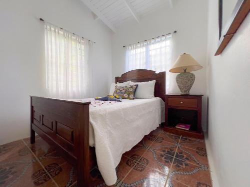 a bedroom with a bed and a table with a lamp at Tropical Retreat in Matthews