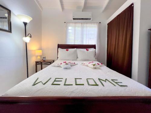 a bedroom with a bed with welcome written on it at Tropical Retreat in Matthews