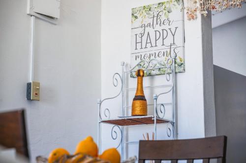 a dining room table with a bottle of champagne on the wall at Tropical Retreat in Matthews