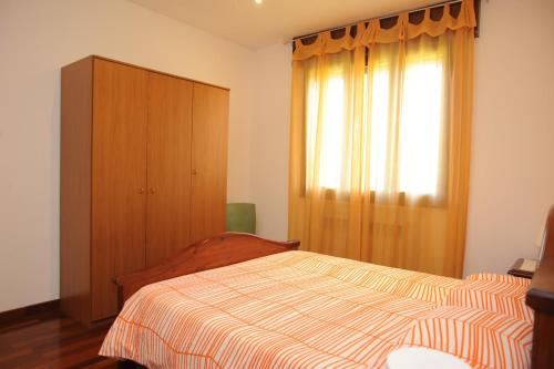 a bedroom with a bed and a dresser and a window at Casa Vacanze Riviera del Brenta in Dolo