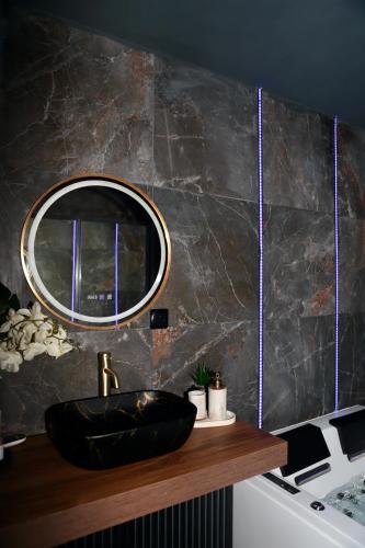 a bathroom with a black sink and a mirror at LoveRoom La Petite Suite avec SPA in Brest
