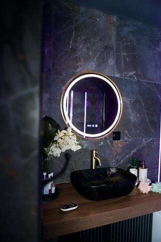 a bathroom with a black sink and a mirror at LoveRoom La Petite Suite avec SPA in Brest