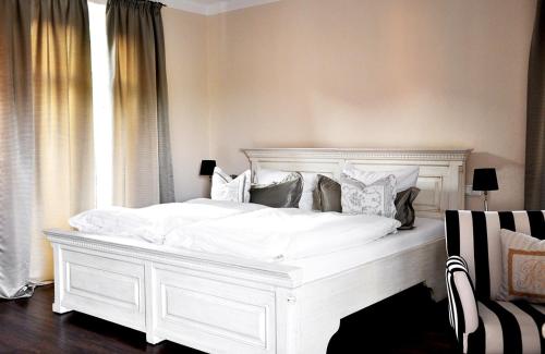 a white bed in a room with a window at Klosterhotel Neuzelle in Neuzelle