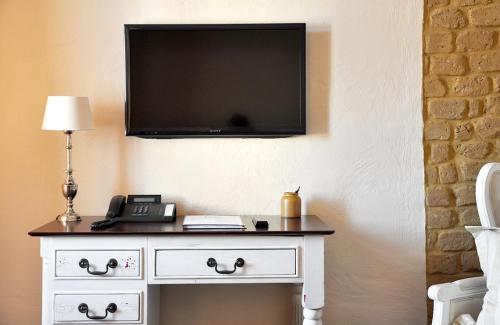 a television on a wall above a white dresser at Klosterhotel Neuzelle in Neuzelle