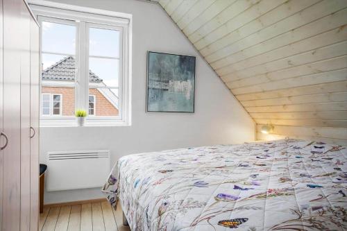 a bedroom with a bed and a window at 0476-Romo-Sonder-Frankel-6 in Havneby