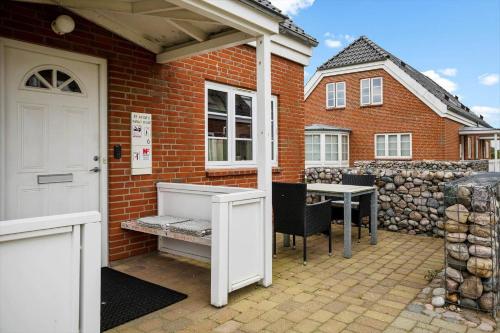 a brick house with a white door and a table at 0476-Romo-Sonder-Frankel-6 in Havneby
