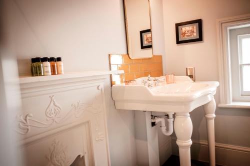 a bathroom with a white sink and a mirror at The Queen's Head in Kingston upon Thames