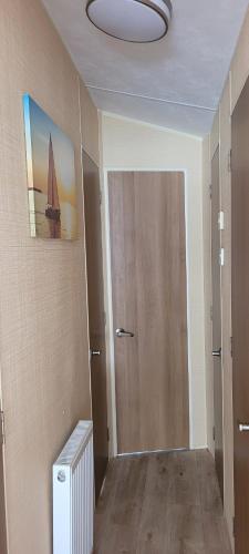 a room with a hallway with a door and a room with at Willerby Delux - Holiday Home by the Sea - close to the Entertainment Complex-bedding, towels & wifi Included! in Jaywick Sands