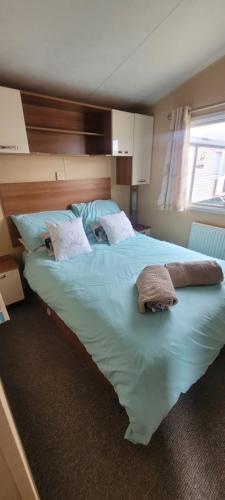 a large bed with two towels on it in a bedroom at Willerby Delux - Holiday Home by the Sea - close to the Entertainment Complex-bedding, towels & wifi Included! in Jaywick Sands