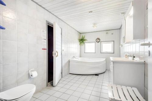 a bathroom with a tub and a toilet and a sink at 0073-Romo-Lakolk-172 in Lakolk
