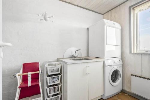 a kitchen with a washing machine and a red chair at 0073-Romo-Lakolk-172 in Lakolk